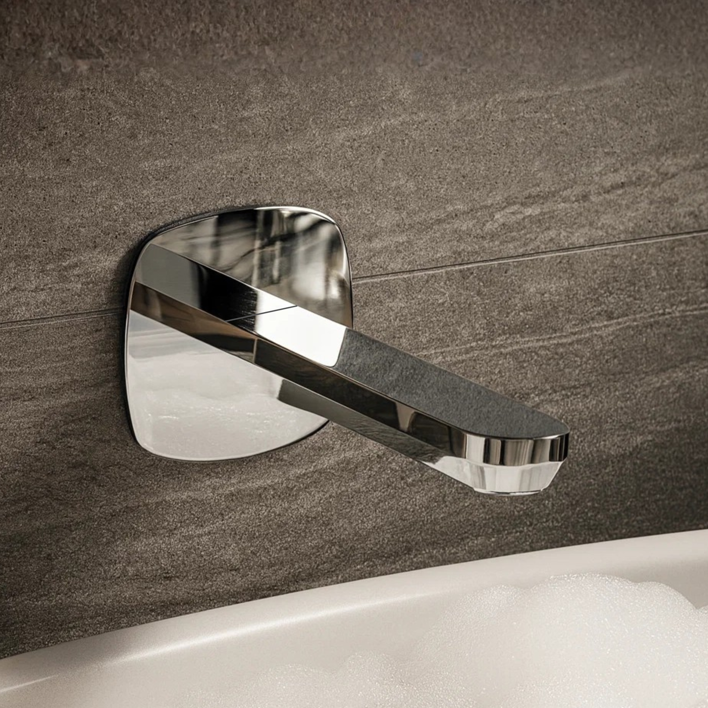 Chrome wall-mounted faucet on a tiled bathroom wall