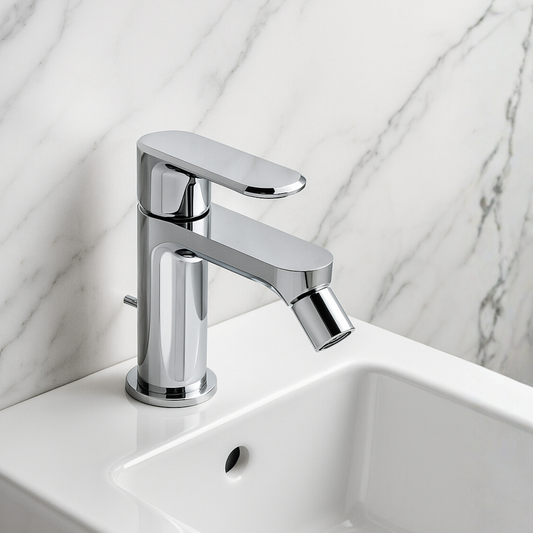 Chrome faucet on a white sink with a marble background