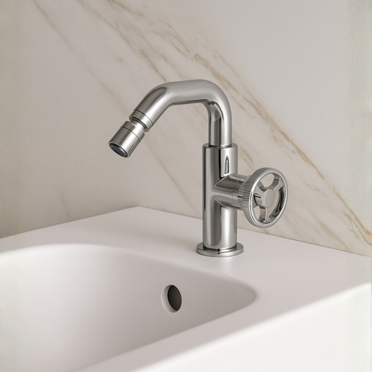 Chrome faucet on a white sink with a marble wall background