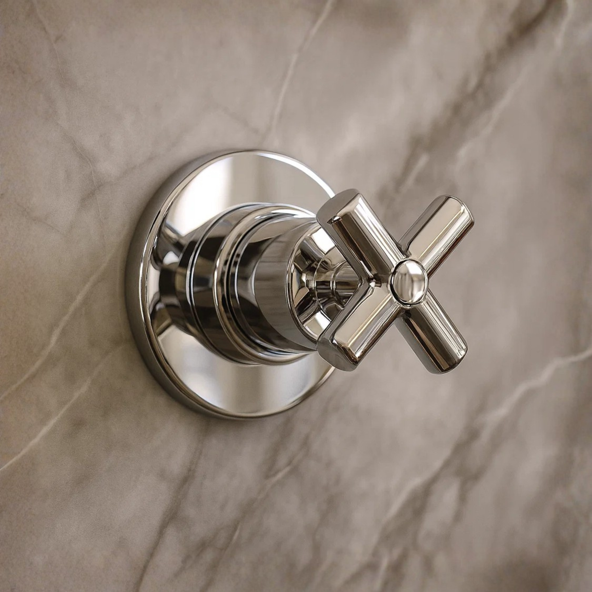 Chrome bathroom valve on a marble wall