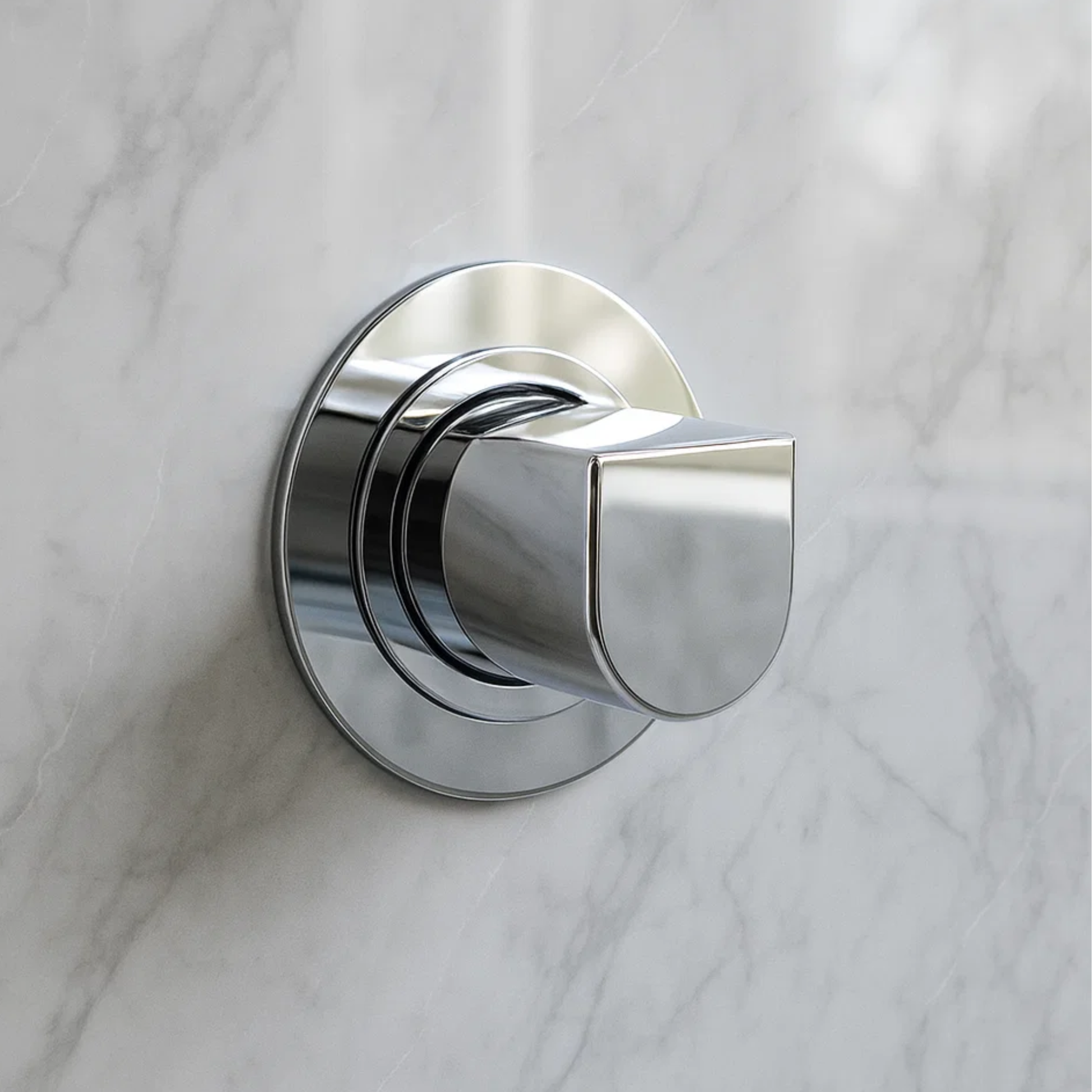 Chrome door handle on a marble wall