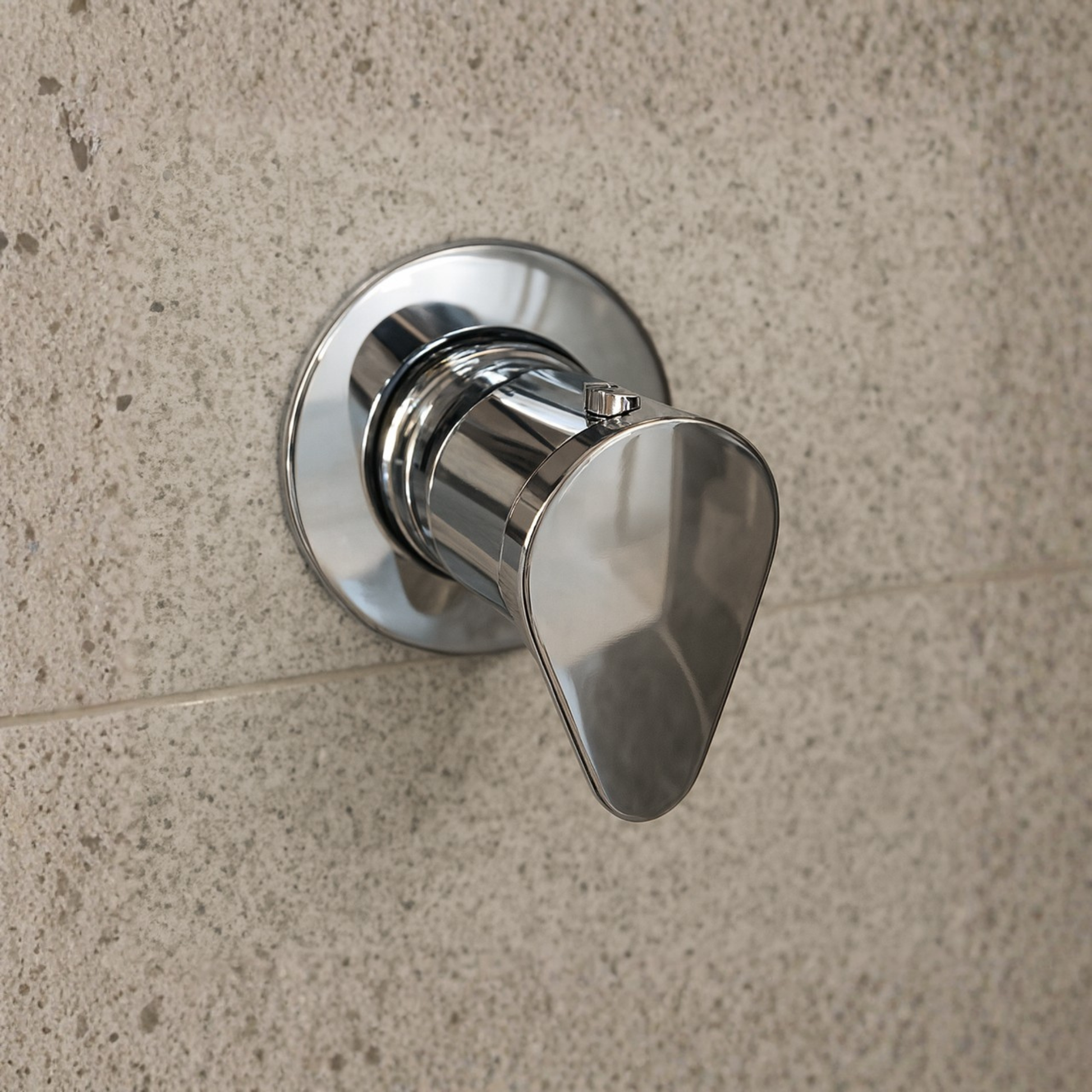 Chrome shower valve handle on a tiled wall