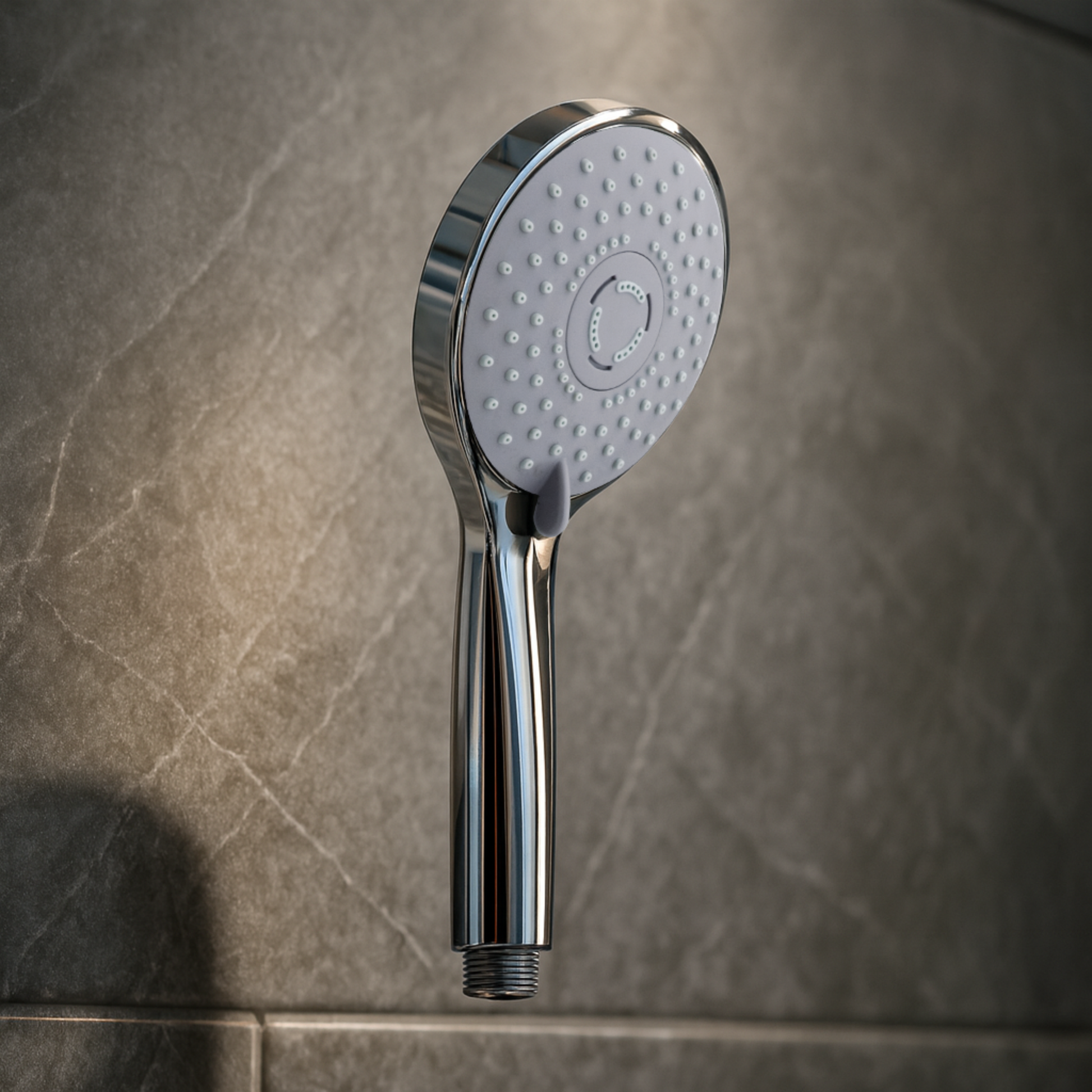 Chrome shower head on a tiled bathroom wall