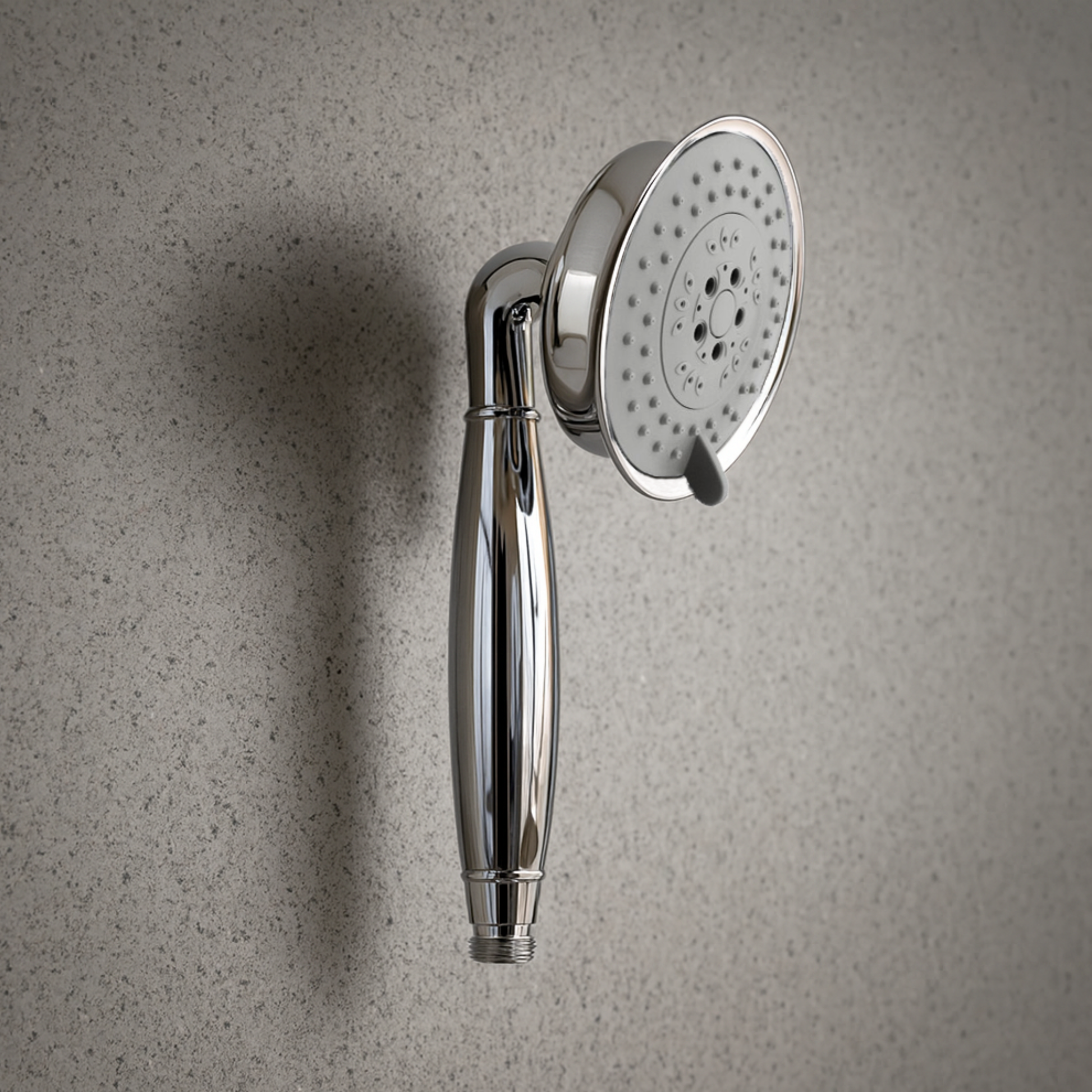 Chrome shower head and handle on a textured gray wall