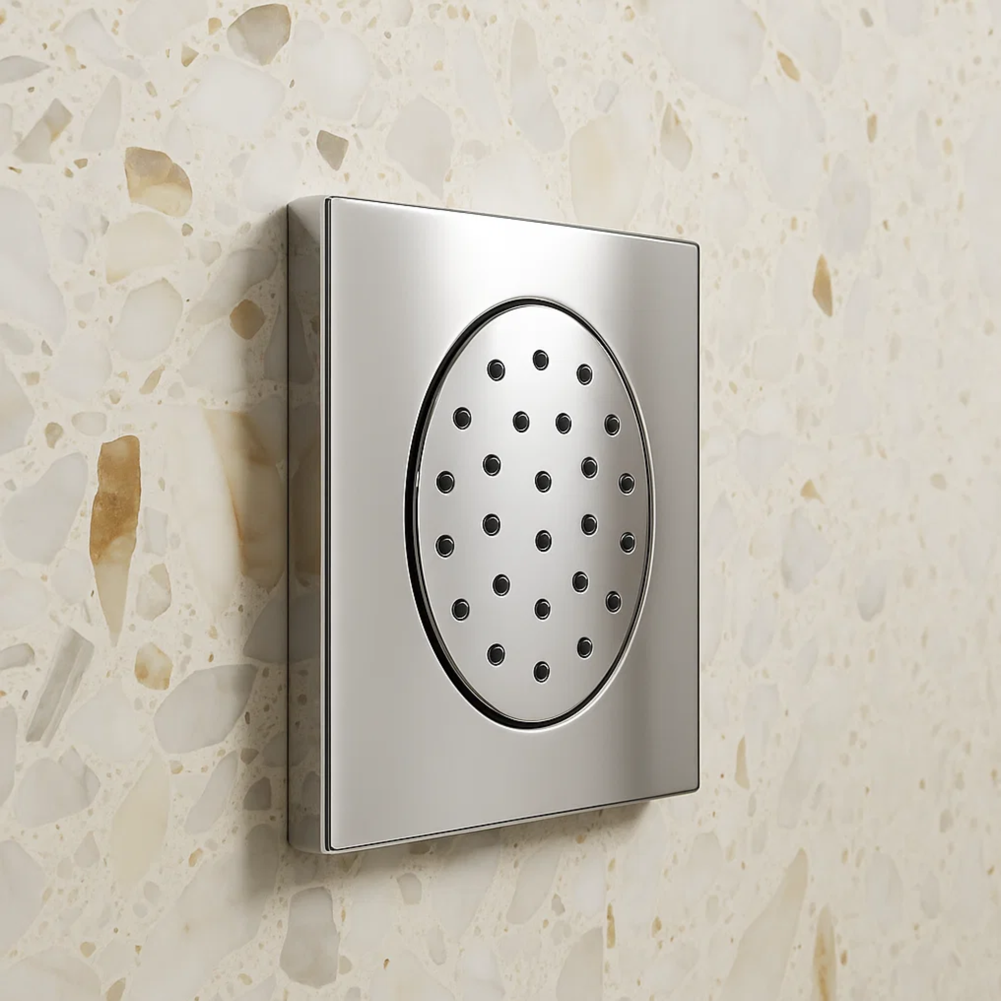 Metallic shower head on a textured beige wall