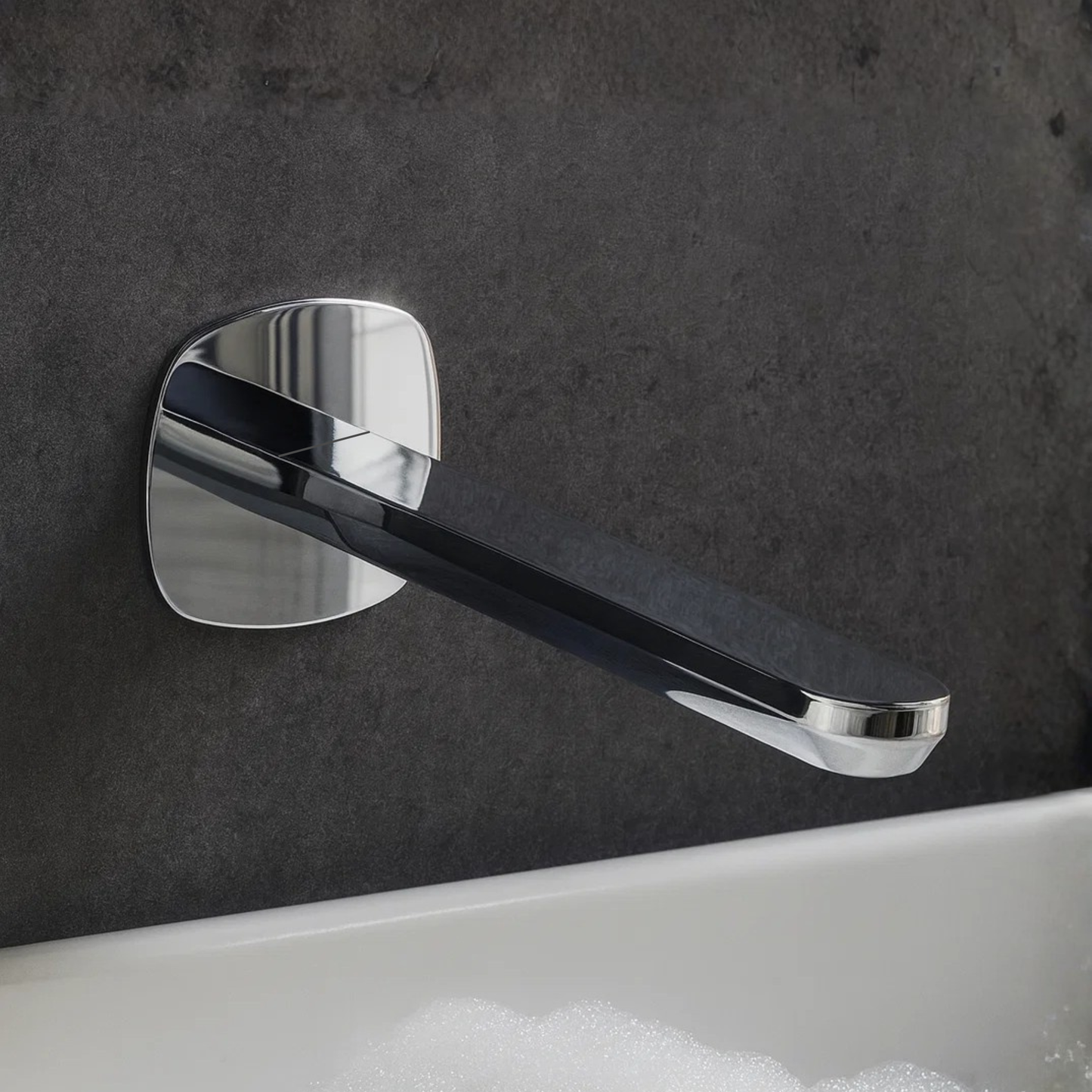 Chrome wall-mounted faucet handle on a dark tiled wall